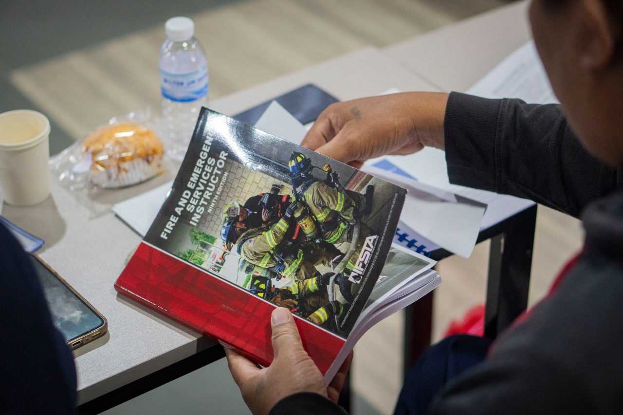 Participant reviewing a fire service instructor reference manual during guided study